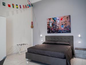 a bedroom with a bed and a painting on the wall at Vesuvian Tales in San Giorgio a Cremano