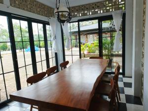 a wooden table and chairs in a room with windows at Jajapin Wangsaloka Syariah in Cijulang