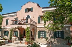 a large brick building with green shutters and a balcony at Villa Andor in Ankaran