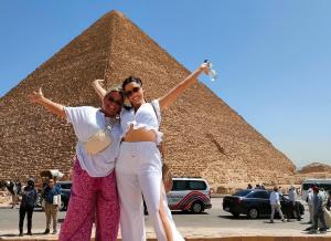 two women posing in front of a pyramid at Pyramids golden rocks inn in Cairo