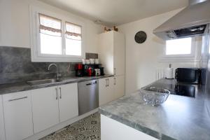 a kitchen with white cabinets and a counter top at Villa Rosa in Roziers-dʼÉgletons