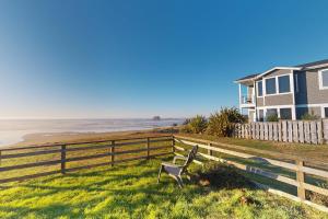 una casa e una recinzione vicino a una spiaggia di Ocean Vista Cottage a Bandon