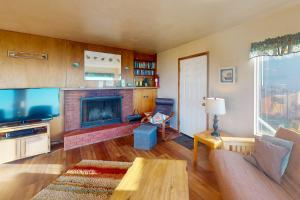 un soggiorno con divano e camino di Ocean Vista Cottage a Bandon