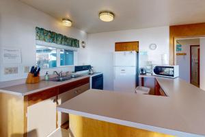 una cucina con lavello e frigorifero di Ocean Vista Cottage a Bandon Altre 15 foto