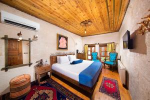 een slaapkamer met een bed en een houten plafond bij Aja Cappadocia Cave Hotel in Urgup