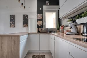 a kitchen with white cabinets and a window at Maison de ville proche de Paris et Disneyland in Pontault-Combault