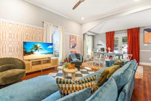 ein Wohnzimmer mit blauen Möbeln und einem Flachbild-TV in der Unterkunft Spacious 4BD - Sleeps 10 - Movie Night & BBQ in Durham