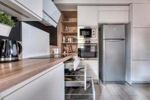 a kitchen with white cabinets and a stainless steel refrigerator at Maison de ville proche de Paris et Disneyland in Pontault-Combault +26 photos