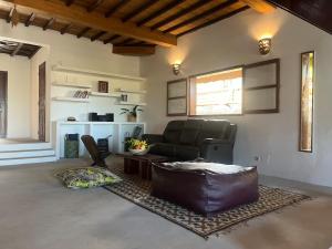 a living room with a leather couch and a table at The Grove 1-4 bedroom beachfront villa in Cap Skirring