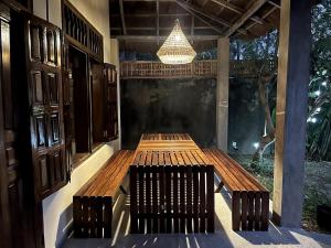 a wooden bench sitting on a patio with a chandelier at The Grove 1-4 bedroom beachfront villa in Cap Skirring