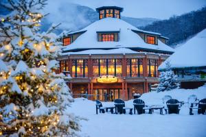 un grand bâtiment recouvert de neige devant dans l'établissement 323 Studio Spruce Peak Lodge At Stowe Mt Resort Sleeps 4, à Stowe Mountain