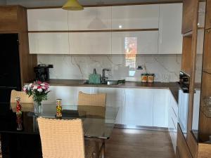 a kitchen with a glass table and a counter at Besa Apartment in Buçimas