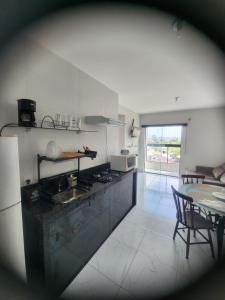 a kitchen with a stove and a table with chairs at apartamento in Tijucas