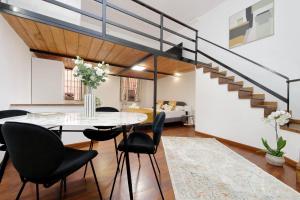 a dining room with a glass table and black chairs at Maison Florienne in Rome
