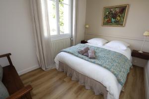 a bedroom with a bed with two stuffed animals on it at Villa Rosa in Roziers-dʼÉgletons