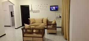 a living room with a couch and chairs and a tv at The Blue Pearl Galle - Free Drop Off to Galle Fort in Galle