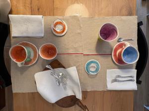 a table with various bowls and utensils on it at Museo Grillo Camere d'Arte, dormire nel Museo in Arena Po