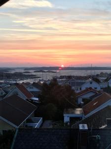 a view of a city with the sunset in the background at Kungshamn - Fisketången in Kungshamn