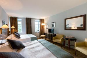 a hotel room with two beds and a desk and a mirror at Les Chambres de L'Ecrit'Vin - En plein coeur du centre-ville in Beaune