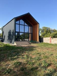 チョルポン・アタにあるESAL Dream Houseの野原にある大きな窓のある小さな建物