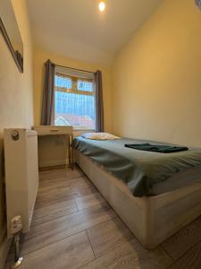 Un dormitorio pequeño con una cama y una ventana. en CR0 Midhurst Serviced Accommodation, en Croydon