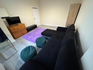 Una sala de estar con un sofá y un televisor. en CR0 Midhurst Serviced Accommodation, en Croydon
