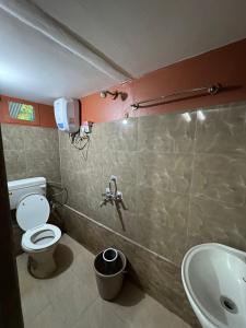 a bathroom with a toilet and a sink at Jajabori homestay in Dibrugarh +5 photos
