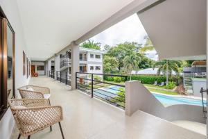 an indoor balcony with chairs and a swimming pool at Paradizio 204 3br Beach-town Condo 7 Guests in Coco