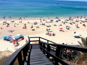 a group of people on a beach with the ocean at Estrela do Mar - Ocean View Apartment - Sesimbra - Falésia in Sesimbra