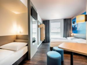 a hotel room with two beds and a table at B&B Hotel Willingen in Willingen