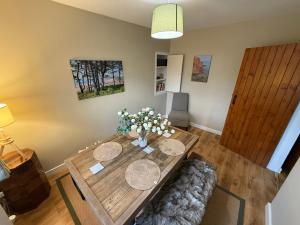 - un salon avec une table en bois et des fleurs dans l'établissement 3 Bed East Devon close to Otter Valley National Nature Reserve and sea, à East Budleigh