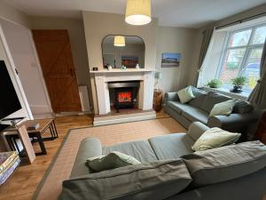 un salon avec un canapé et une cheminée dans l'établissement 3 Bed East Devon close to Otter Valley National Nature Reserve and sea, à East Budleigh