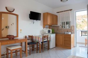 a small kitchen with a table and a microwave at Nephele Apartments in Faliraki
