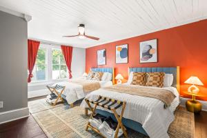 2 Betten in einem Zimmer mit orangefarbenen Wänden in der Unterkunft Spacious 4BD - Sleeps 10 - Movie Night & BBQ in Durham