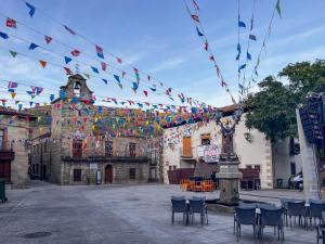 ein Innenhof mit Tischen und Stühlen und Fahnen in der Unterkunft Casa en sierra de gredos piscina privada in La Adrada