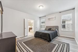 a white bedroom with a bed and a rug at Mansfield House Texas in Mansfield