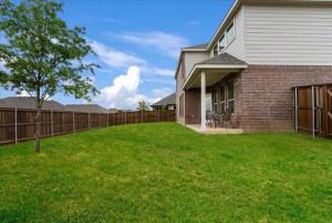 a house with a fence and a grass yard at Mansfield House Texas in Mansfield