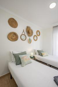 two beds in a room with hats on the wall at Aguda Beach Porto, Slow Travel Houses in Vila Nova de Gaia