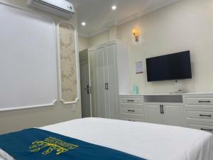 a bedroom with a bed and a flat screen tv at Platinum in Xóm Hương Phùng