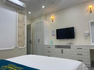 a bedroom with a bed and a flat screen tv at Platinum in Xóm Hương Phùng