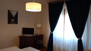 a bedroom with a bed and a window with curtains at Home in Arezzo