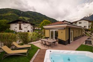 a backyard with a pool and a table and chairs at Villa Ilaria in Lagundo