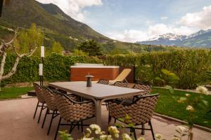 a table and chairs with mountains in the background at Villa Ilaria in Lagundo