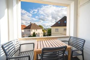 a balcony with a wooden table and two chairs at Malu Rooms - Attraktive Lage, Balkon, SmartTv, 24h Checkin, Waschmaschine, in Ludwigsburg