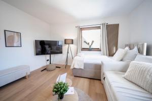 a living room with a bed and a couch at Malu Rooms - Attraktive Lage, Balkon, SmartTv, 24h Checkin, Waschmaschine, in Ludwigsburg