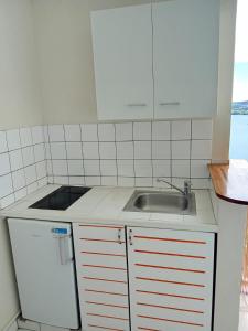 a kitchen with a sink and a counter top at Studio du PARADIS et Maison Vue sur Mer à 10 minutes des belles plages in Le Marin