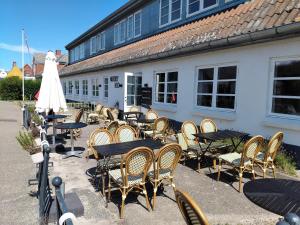 a group of tables and chairs in front of a building at Nordby Kro in Nordby