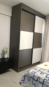 a bedroom with a bed with a black and white headboard at Quick Connect Studio Kileleshwa in Nairobi
