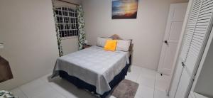 Cottage at Coverley في كرايست تشيرش: غرفة نوم صغيرة مع سرير مع وسادة برتقال