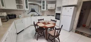 Cottage at Coverley في كرايست تشيرش: مطبخ مع طاولة وكراسي وثلاجة